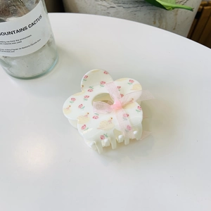 Detail of floral claw clip with white base, pink roses, duck pattern and ribbon bow