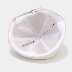 Inside view of beige cotton docker cap showing adjustable strap and stitching detail