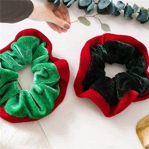 Detail of two-pack Christmas velvet scrunchies in green and red with soft thick texture