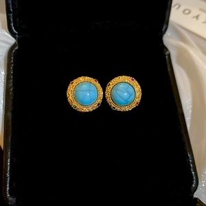 Detailed close-up of vintage 18k gold plated stud earrings with turquoise and zircon