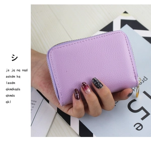Detailed view of a purple pebble leather card holder featuring a gold zipper closure