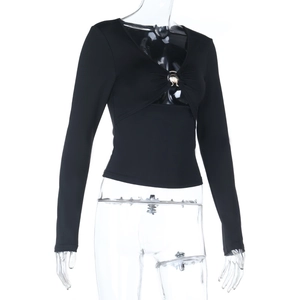 Close-up of a slim-fit black V-neck top featuring a golden metal ring detail on the front
