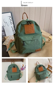 Close-up of green canvas backpack featuring a brown leather smiley patch and side pockets