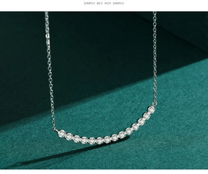 Macro shot of silver S925 necklace with shiny cubic zirconia stones on green background
