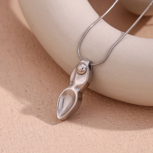 Détail du pendentif dague géométrique argenté sur une chaîne serpent minimaliste