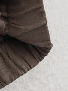 Close-up of deep brown suede jacket cuff showing high-density twill texture and elastic details