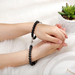 Close-up of magnetic heart clasp on couples black natural stone beaded bracelets
