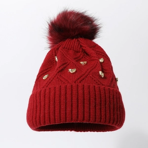 Bonnet en maille torsadée bordeaux avec pompon moelleux et ornements métalliques dorés