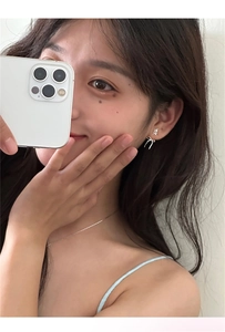 Dettaglio dell'orecchino a fiocco argento e collana indossati in uno scatto selfie