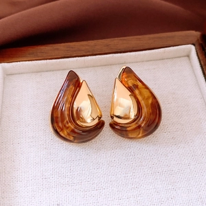 Detailed view of teardrop resin earrings with amber marble texture and 18K gold plated metal