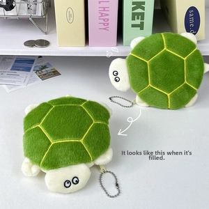 Detail of plush turtle coin purse with embroidered eyes and green shell texture