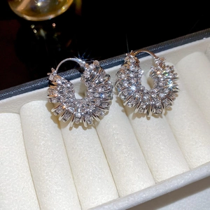 Close-up of silver-toned U-shaped earrings with sparkling cubic zirconia on velvet