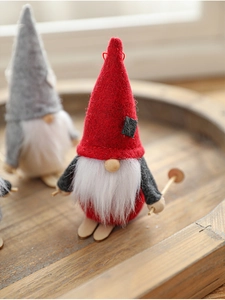 Detail of a handmade Christmas gnome featuring a felt hat and wooden ski accessories