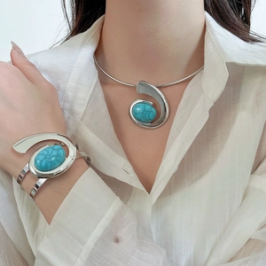 Detail of silver collar necklace and bracelet set with oval turquoise stones on a model