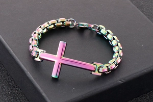 Macro view of rainbow stainless steel cross bracelet on a textured black gift box