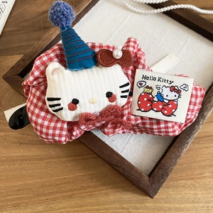 Close-up of red and white plaid bow hair clip featuring a plush Hello Kitty icon