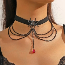 Close-up of gothic black spider choker with layered chains and red teardrop pendant