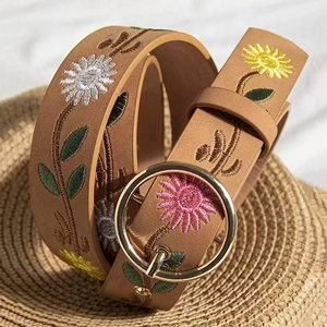 Detail of brown faux leather belt with embroidered sunflowers and golden round buckle