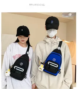 Détail de sacs de poitrine en toile noir et bleu roi avec pendentifs en peluche