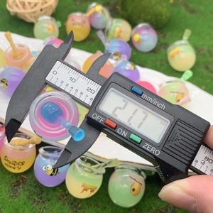 Macro shot of a 21.7mm colorful resin honey jar charm measured by a digital caliper