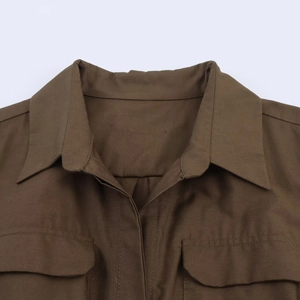 Detail of lapel collar and flap pockets on a dark brown poplin shirt dress