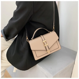 Detailed view of a beige PU leather crossbody bag with gold hardware on a model