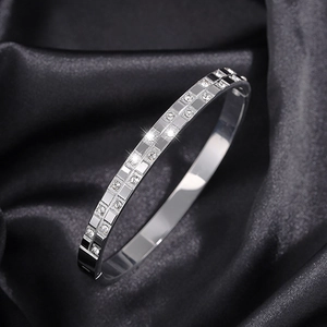 Macro shot of silver waffle pattern bracelet with sparkling cubic zirconia on silk