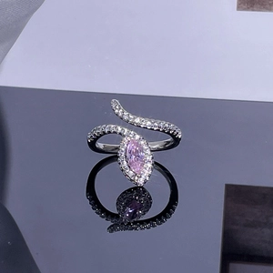 Macro shot of wavy silver ring with marquise pink stone and pave set zircons