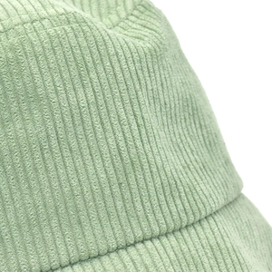 Gros plan montrant la texture en velours côtelé du chapeau bob de couleur vert clair