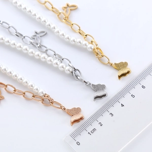 Stainless steel butterfly pendant bracelets with imitation pearls shown with a scale ruler