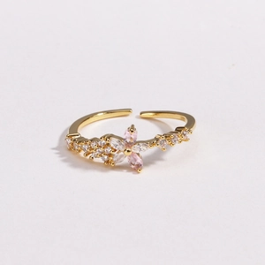 Gros plan détaillé d'une bague fleur dorée sertie de zircons roses et blancs fins