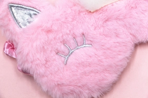 Detailed macro view of soft pink plush unicorn eye mask with delicate eyelash embroidery