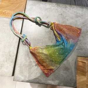 Detail of triangle rhinestone shoulder bag featuring rainbow gradient crystal finish