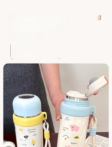 Detail view of cartoon thermal cup with dual-use lid, woven strap and sheep illustration
