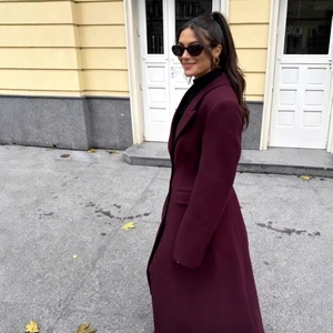 Elegante cappotto lungo in lana bordeaux con revers e vita alta in silhouette da passeggio