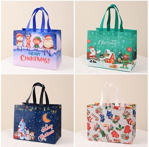 Detail of four festive non-woven Christmas gift bags in blue, green and white colors