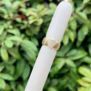 Macro shot of wide mesh band gold ring featuring a sparkling heart-shaped zirconia setting