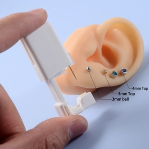 Disposable ear piercing gun with 316L studs shown on a silicone ear model demo