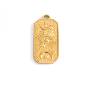 Detailed macro view of an 18k gold rectangular pendant with embossed eye and moon motifs