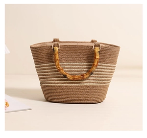 Close-up of woven straw handbag featuring striped texture and natural bamboo handle