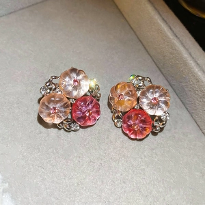 Macro detail of sweet floral stud earrings with translucent petals and rhinestone accents