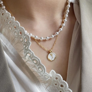 Double-layered gold necklace with white pearls and a vintage rose flower pendant