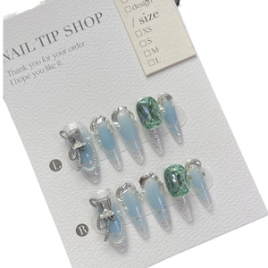 Luxurious light blue press-on nails set with emerald gems and silver glitter butterfly