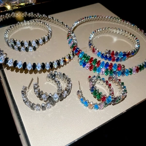 Detailansicht der Tropfen-Zirkon-Schmucksets mit silbernen Armbändern und Halsketten