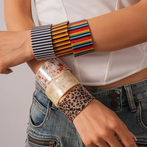 Close-up of stacked acrylic resin bangles with marble and stripe patterns on a model