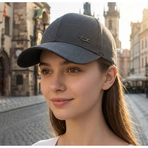 Detail of dark gray baseball cap with grid texture and silver metal script logo