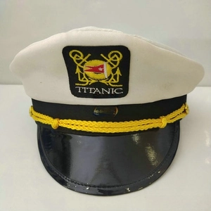 Detailed embroidery of Titanic anchor and flags on a white captain hat with rope trim