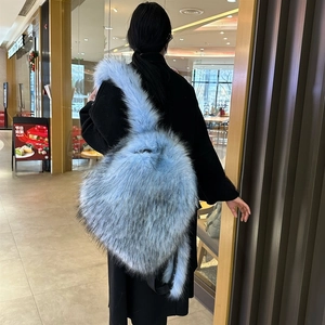 Detailaufnahme von flauschigem Kunstpelz-Rucksack in Hellblau am Model-Rücken