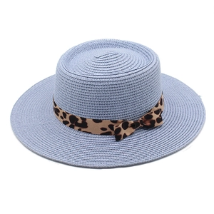 Close-up of light blue straw boater hat with a leopard print ribbon bow for summer