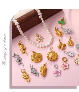 Macro shot of gold and silver flower pendants with zircons on a pink surface